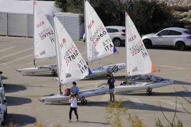 İtalya, Sicilya, Akdeniz, Marina di Ragusa; 9 Şubat 2024, limandaki insanlar ve yelkenliler - EDITORIAL