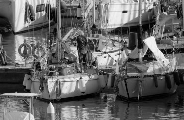 İtalya, Sicilya, Akdeniz, Marina di Ragusa (Ragusa Eyaleti); 16 Şubat 2024, limandaki bir yelkenli teknesinde adam - EDITORIAL