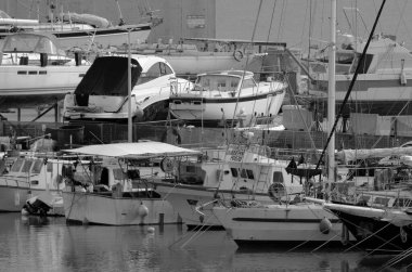 İtalya, Sicilya, Marina di Ragusa (Ragusa Eyaleti); 29 Şubat 2024, yerel balıkçı tekneleri ve limanda bir yelkenli teknesi - EDITORIAL