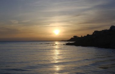 İtalya, Sicilya, Marinella di Selinunte (Trapani Eyaleti), gün batımında kayalık kıyı şeridi manzarası