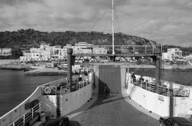 İtalya, Sicilya, Akdeniz, Egadi takımadaları, Levanzo Adası (Trapani Eyaleti); 20 Mart 2024, adanın kayalık kıyıları ve liman bir feribot - EDITORIAL