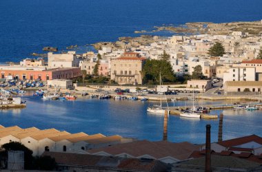 İtalya, Sicilya, Akdeniz, Egadi takımadaları, Favignana Adası (Trapani Eyaleti); liman manzarası, Florio Sarayı ve eski balık avlama fabrikası çatıları