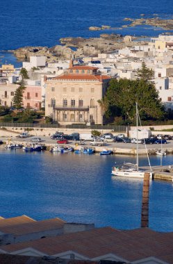 İtalya, Sicilya, Akdeniz, Egadi takımadaları, Favignana Adası (Trapani Eyaleti); liman manzarası, Florio Sarayı ve eski balık avlama fabrikası çatıları 