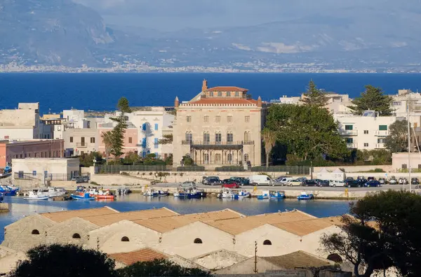 İtalya, Sicilya, Akdeniz, Egadi takımadaları, Favignana Adası (Trapani Eyaleti); liman, Florio Sarayı ve arka plandaki eski orkinos balıkçılık fabrikası çatıları (Trapani ve Sicilya kıyıları) manzarası)