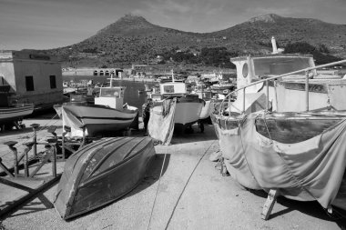 İtalya, Sicilya, Akdeniz, Egadi takımadaları, Favignana Adası (Trapani Eyaleti); limanda insanlar ve balıkçı tekneleri (arka plandaki eski ton balığı fabrikası))