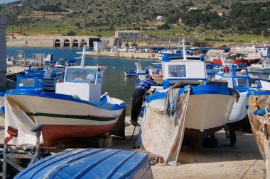 İtalya, Sicilya, Akdeniz, Egadi takımadaları, Favignana Adası (Trapani Eyaleti); limanda insanlar ve balıkçı tekneleri (arka plandaki eski ton balığı fabrikası))