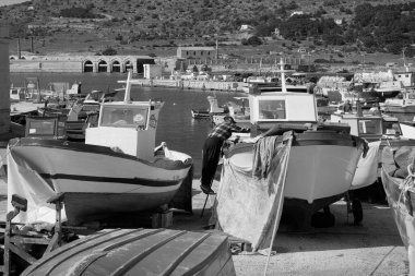 İtalya, Sicilya, Akdeniz, Egadi takımadaları, Favignana Adası (Trapani Eyaleti); limanda insanlar ve balıkçı tekneleri (arka plandaki eski ton balığı fabrikası))