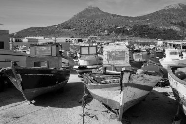 İtalya, Sicilya, Akdeniz, Egadi takımadaları, Favignana Adası (Trapani Eyaleti); 21 Mart 2024, limanda ahşap balıkçı tekneleri (arka planda eski ton balığı fabrikası) -