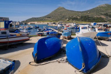 İtalya, Sicilya, Akdeniz, Egadi takımadaları, Favignana Adası (Trapani Eyaleti); 21 Mart 2024, limanda ahşap balıkçı tekneleri (arka planda eski ton balığı fabrikası) -