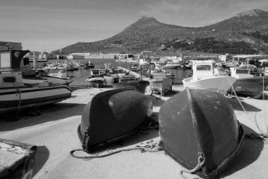 İtalya, Sicilya, Akdeniz, Egadi takımadaları, Favignana Adası (Trapani Eyaleti); 21 Mart 2024, limanda ahşap balıkçı tekneleri (arka planda eski ton balığı fabrikası) -