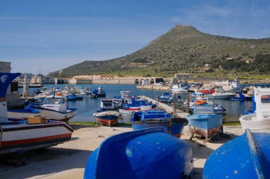 İtalya, Sicilya, Akdeniz, Egadi takımadaları, Favignana Adası (Trapani Eyaleti); 21 Mart 2024, limanda ahşap balıkçı tekneleri (arka planda eski ton balığı fabrikası) -