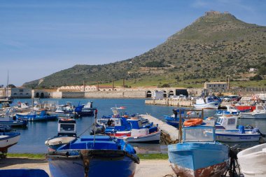 İtalya, Sicilya, Akdeniz, Egadi takımadaları, Favignana Adası (Trapani Eyaleti); 21 Mart 2024, limanda ahşap balıkçı tekneleri (arka planda eski ton balığı fabrikası) -
