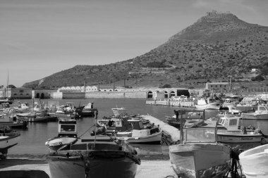 İtalya, Sicilya, Akdeniz, Egadi takımadaları, Favignana Adası (Trapani Eyaleti); 21 Mart 2024, limanda ahşap balıkçı tekneleri (arka planda eski ton balığı fabrikası) -