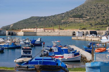 İtalya, Sicilya, Akdeniz, Egadi takımadaları, Favignana Adası (Trapani Eyaleti); 21 Mart 2024, limanda ahşap balıkçı tekneleri (arka planda eski ton balığı fabrikası) -