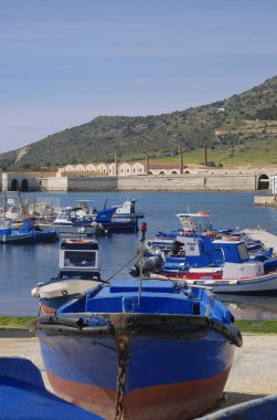 İtalya, Sicilya, Akdeniz, Egadi takımadaları, Favignana Adası (Trapani Eyaleti); 21 Mart 2024, limanda ahşap balıkçı tekneleri (arka planda eski ton balığı fabrikası) -