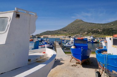 İtalya, Sicilya, Akdeniz, Egadi takımadaları, Favignana Adası (Trapani Eyaleti); Limandaki ahşap balıkçı tekneleri (arka plandaki eski ton balığı fabrikası)