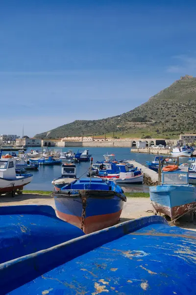 İtalya, Sicilya, Akdeniz, Egadi takımadaları, Favignana Adası (Trapani Eyaleti); Limandaki ahşap balıkçı tekneleri (arka plandaki eski ton balığı fabrikası)