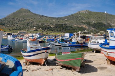 İtalya, Sicilya, Akdeniz, Egadi takımadaları, Favignana Adası (Trapani Eyaleti); limandaki insanlar ve balıkçı tekneleri (arka plandaki eski ton balığı fabrikası))