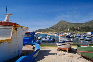 İtalya, Sicilya, Akdeniz, Egadi takımadaları, Favignana Adası (Trapani Eyaleti); 21 Mart 2024, limanda ahşap balıkçı tekneleri (arka planda eski ton balığı fabrikası) -