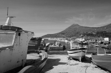 İtalya, Sicilya, Akdeniz, Egadi takımadaları, Favignana Adası (Trapani Eyaleti); 21 Mart 2024, limanda ahşap balıkçı tekneleri (arka planda eski ton balığı fabrikası) -