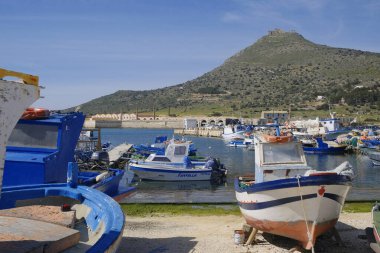 İtalya, Sicilya, Akdeniz, Egadi takımadaları, Favignana Adası (Trapani Eyaleti); 21 Mart 2024, limanda ahşap balıkçı tekneleri (arka planda eski ton balığı fabrikası) -