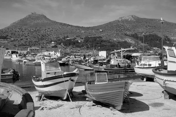 İtalya, Sicilya, Akdeniz, Egadi takımadaları, Favignana Adası (Trapani Eyaleti); limandaki insanlar ve balıkçı tekneleri (arka plandaki eski ton balığı fabrikası))