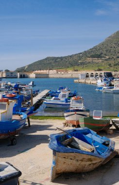 İtalya, Sicilya, Akdeniz, Egadi takımadaları, Favignana Adası (Trapani Eyaleti); 21 Mart 2024, limanda ahşap balıkçı tekneleri (arka planda eski ton balığı fabrikası) -