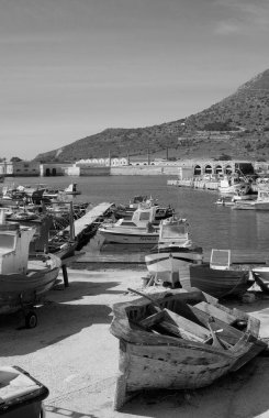 İtalya, Sicilya, Akdeniz, Egadi takımadaları, Favignana Adası (Trapani Eyaleti); 21 Mart 2024, limanda ahşap balıkçı tekneleri (arka planda eski ton balığı fabrikası) -