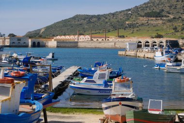 İtalya, Sicilya, Akdeniz, Egadi takımadaları, Favignana Adası (Trapani Eyaleti); 21 Mart 2024, limanda ahşap balıkçı tekneleri (arka planda eski ton balığı fabrikası) -