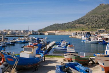 İtalya, Sicilya, Akdeniz, Egadi takımadaları, Favignana Adası (Trapani Eyaleti); 21 Mart 2024, limanda ahşap balıkçı tekneleri (arka planda eski ton balığı fabrikası) -