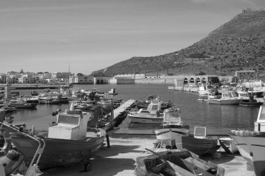 İtalya, Sicilya, Akdeniz, Egadi takımadaları, Favignana Adası (Trapani Eyaleti); 21 Mart 2024, limanda ahşap balıkçı tekneleri (arka planda eski ton balığı fabrikası) -