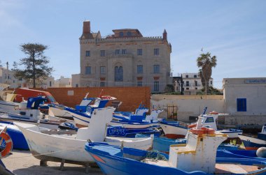 İtalya, Sicilya, Akdeniz, Egadi takımadaları, Favignana Adası (Trapani Eyaleti), limanda kıyıda tekneler ve Florio Sarayı cephesi