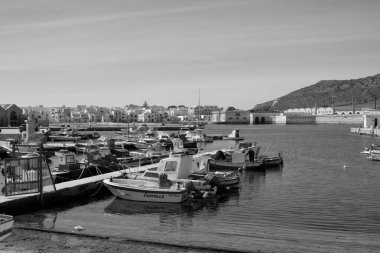 İtalya, Sicilya, Akdeniz, Egadi takımadaları, Favignana Adası (Trapani Eyaleti); 21 Mart 2024, limanda ahşap balıkçı tekneleri (arka planda eski ton balığı fabrikası) -