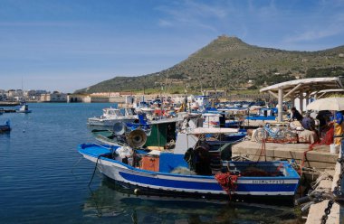 İtalya, Sicilya, Akdeniz, Egadi takımadaları, Favignana Adası (Trapani Eyaleti); limanda insanlar ve ahşap balıkçı tekneleri (arka plandaki eski ton balığı fabrikası)) 