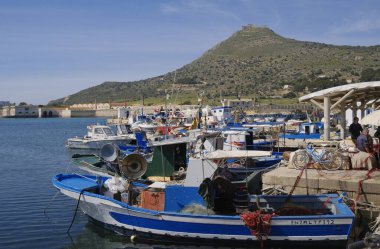 İtalya, Sicilya, Akdeniz, Egadi takımadaları, Favignana Adası (Trapani Eyaleti); limanda insanlar ve ahşap balıkçı tekneleri (arka plandaki eski ton balığı fabrikası)) 