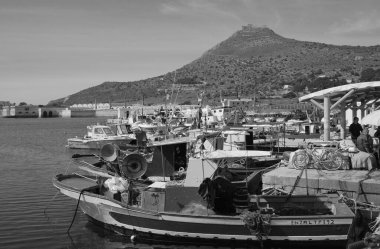 İtalya, Sicilya, Akdeniz, Egadi takımadaları, Favignana Adası (Trapani Eyaleti); limanda insanlar ve ahşap balıkçı tekneleri (arka plandaki eski ton balığı fabrikası)) 