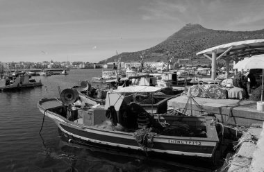 İtalya, Sicilya, Akdeniz, Egadi takımadaları, Favignana Adası (Trapani Eyaleti); limanda insanlar ve ahşap balıkçı tekneleri (arka plandaki eski ton balığı fabrikası)) 