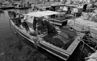 İtalya, Sicilya, Akdeniz, Egadi takımadaları, Favignana Adası (Trapani Eyaleti); 21 Mart 2024, limandaki ahşap balıkçı teknesinde balıkçı...