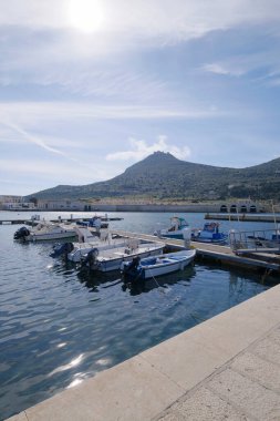 İtalya, Sicilya, Akdeniz, Egadi takımadaları, Favignana Adası (Trapani Eyaleti); 21 Mart 2024, limanda balıkçı tekneleri (arka planda eski ton balığı fabrikası) -