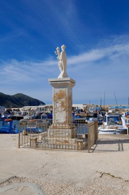 İtalya, Sicilya, Akdeniz, Egadi takımadaları, Favignana Adası (Trapani Eyaleti); limandaki Madonna heykeli ve balıkçı tekneleri manzarası 