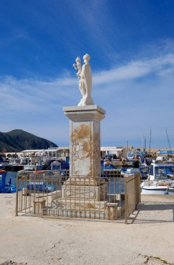 İtalya, Sicilya, Akdeniz, Egadi takımadaları, Favignana Adası (Trapani Eyaleti); limandaki Madonna heykeli ve balıkçı tekneleri manzarası 