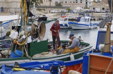 İtalya, Sicilya, Akdeniz, Egadi takımadaları, Favignana Adası (Trapani Eyaleti); 22 Mart 2024, limanda balıkçılar, balıkçılar, balıkçı tekneleri ve ağlar - EDITORIAL