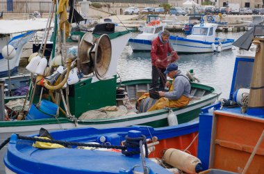 İtalya, Sicilya, Akdeniz, Egadi takımadaları, Favignana Adası (Trapani Eyaleti); 22 Mart 2024, limanda balıkçılar, balıkçılar, balıkçı tekneleri ve ağlar - EDITORIAL