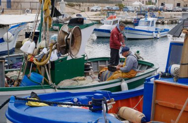 İtalya, Sicilya, Akdeniz, Egadi takımadaları, Favignana Adası (Trapani Eyaleti); 22 Mart 2024, limanda balıkçılar, balıkçılar, balıkçı tekneleri ve ağlar - EDITORIAL