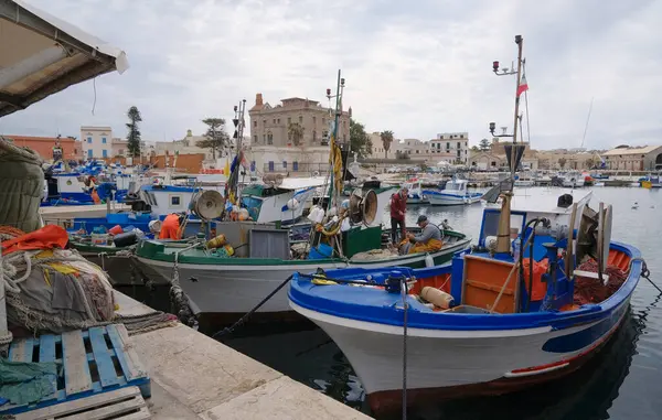 İtalya, Sicilya, Akdeniz, Egadi takımadaları, Favignana Adası (Trapani Eyaleti); 22 Mart 2024, balıkçılar, balıkçılar, balıkçı tekneleri ve ağlar limanda (arkada Florio Sarayı) - EDITORIAL