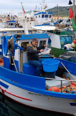 İtalya, Sicilya, Akdeniz, Egadi takımadaları, Favignana Adası (Trapani Eyaleti); 22 Mart 2025, limanda balıkçılar, balıkçılar, balıkçı tekneleri ve ağlar - EDITORIAL