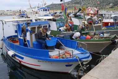 İtalya, Sicilya, Akdeniz, Egadi takımadaları, Favignana Adası (Trapani Eyaleti); 22 Mart 2025, limanda balıkçılar, balıkçılar, balıkçı tekneleri ve ağlar - EDITORIAL