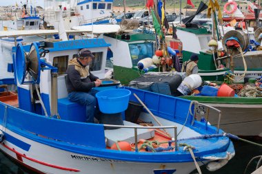 İtalya, Sicilya, Akdeniz, Egadi takımadaları, Favignana Adası (Trapani Eyaleti); 22 Mart 2025, limanda balıkçılar, balıkçılar, balıkçı tekneleri ve ağlar - EDITORIAL