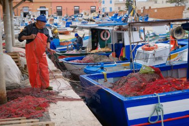 İtalya, Sicilya, Akdeniz, Egadi takımadaları, Favignana Adası (Trapani Eyaleti); 22 Mart 2025, limanda balıkçılar, balıkçılar, balıkçı tekneleri ve ağlar - EDITORIAL