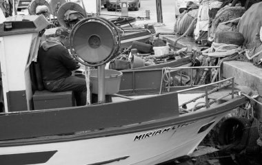 İtalya, Sicilya, Akdeniz, Egadi takımadaları, Favignana Adası (Trapani Eyaleti); 22 Mart 2024, limanda balıkçılar, balıkçılar, balıkçı tekneleri ve ağlar - EDITORIAL